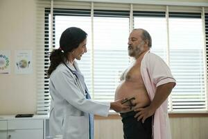 hembra médico y profesional nutricionista en uniforme con calibrar examinar blanco pacientes por soportes y grasa medida, chequeos para sano dieta a clínica hospital, y equipo visita. foto