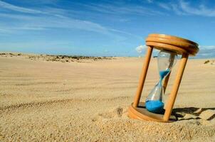 Hourglass on the sand photo