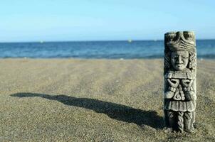 Pre columbian miniature on beach sand photo