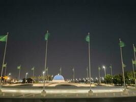 Jeddah, Saudi Arabia, June 2023 - A beautiful view of Saudi Arabian flags flying at Jeddah Corniche Road intersection at night. photo