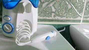 Home dental care device - water flosser in the bathroom. Closeup video