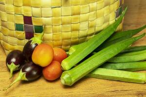 Vegetables outside in a basket on a wooden table, close up photo