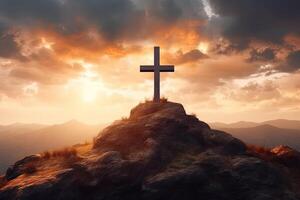 Cross on the top of the mountain with sunset background. photo