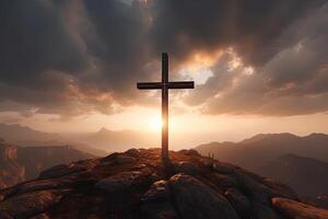 Cross on the top of the mountain with sunset background. photo