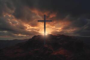 Cross on the top of the mountain with sunset background. photo