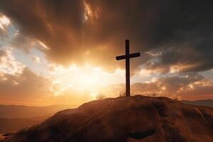 Cross on the top of the mountain with sunset background. photo