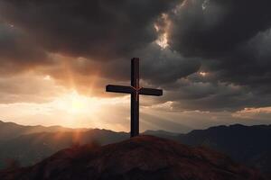 Cross on the top of the mountain with sunset background. photo