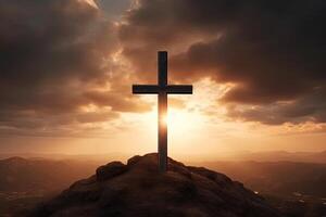 Cross on the top of the mountain with sunset background. photo