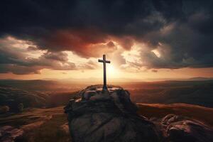 Cross on the top of the mountain with sunset background. photo