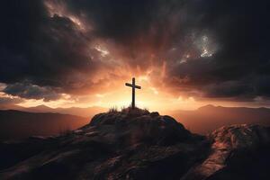 Cross on the top of the mountain with sunset background. photo