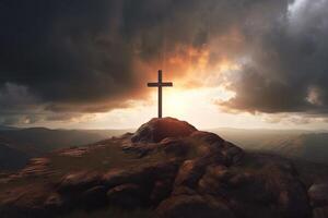 Cross on the top of the mountain with sunset background. photo