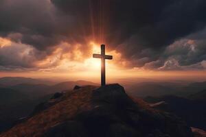 Cross on the top of the mountain with sunset background. photo