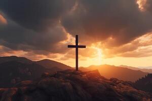 Cross on the top of the mountain with sunset background. photo