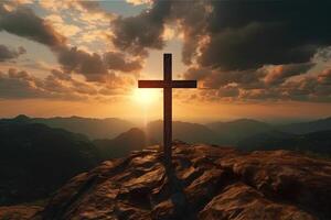 Cross on the top of the mountain with sunset background. photo