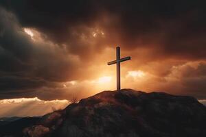 Cross on the top of the mountain with sunset background. photo