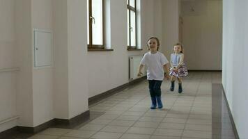 Boy and girl running in the corridor. Wide shot video