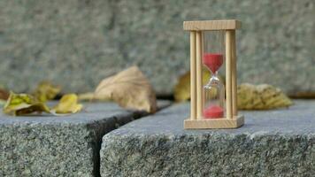 sabbia orologio nel di legno fama su un' grigio pietra. avvicinamento video