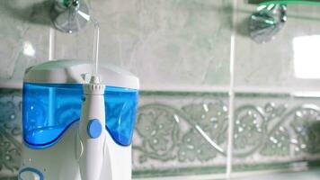 Home dental care device - water flosser in the bathroom. Closeup video