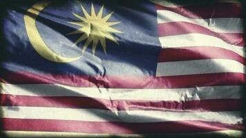 retro envelhecido Malásia bandeira acenando em a vento. velho vintage malaio bandeira balançando em a brisa. desatado laço. video