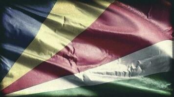 Retro aged Seychelles flag waving on the wind. Old vintage banner swaying on the breeze. Seamless loop. video