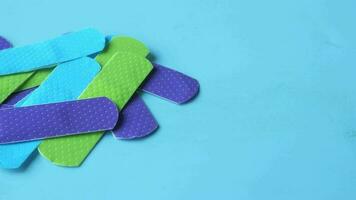 Colorful adhesive bandage on blue background video