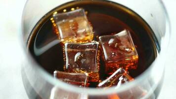 Ice in a cold soft drinks in a glass on table video