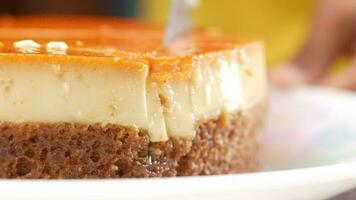 Cutting Caramel custard pudding on a plate on table video