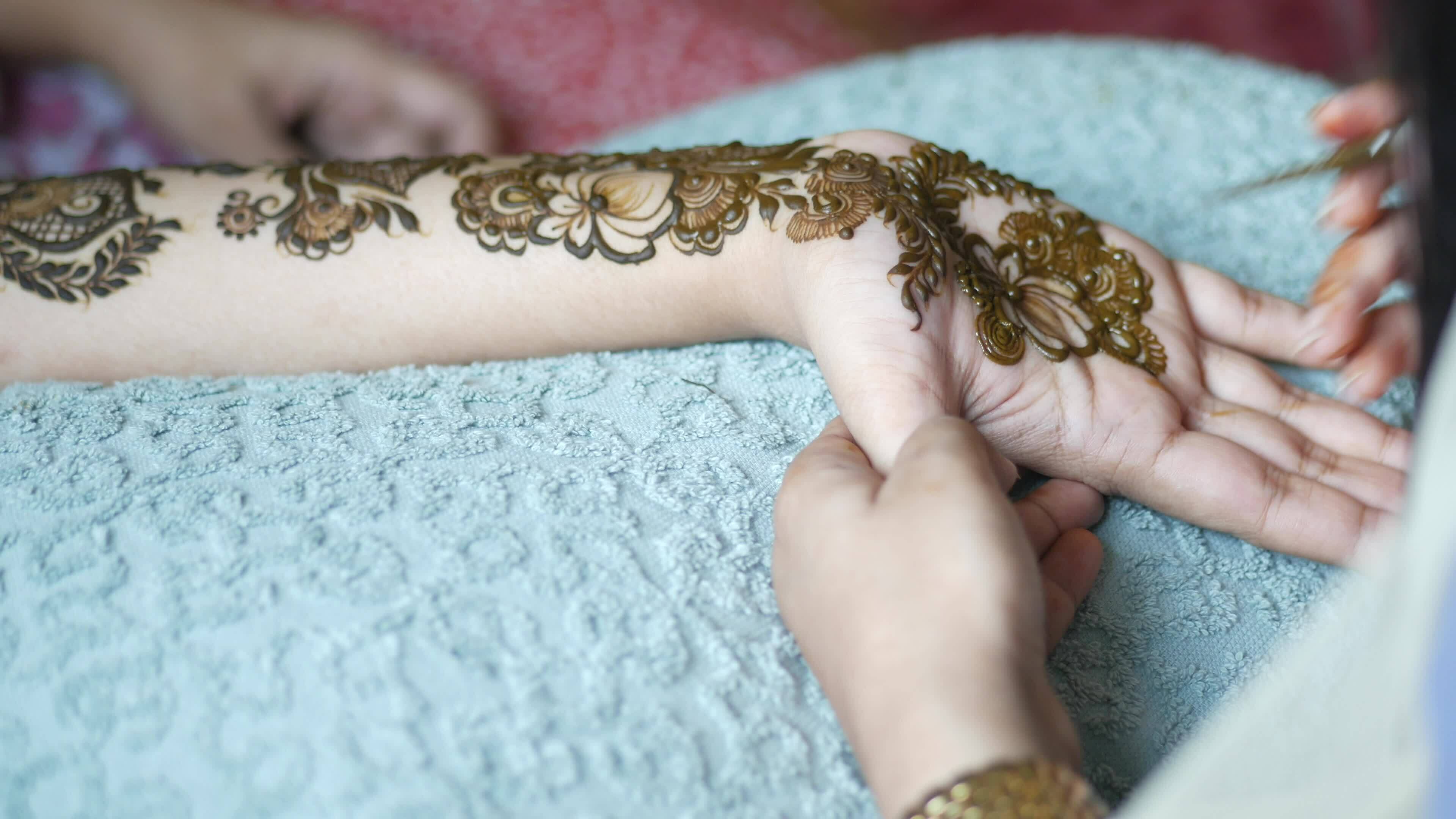 women applying henna on hand 25259750 Stock Video at Vecteezy