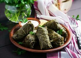 Dolma. Stuffed grape leaves with rice and meat on dark table. Middle eastern cuisine. photo