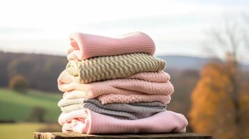 Laundry, housekeeping and homemaking, stack of clean and folded knitted clothes in the countryside, photo