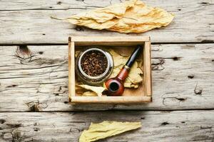 Smoking pipe with tobacco leaves photo