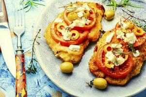 Schnitzel with olives and tomato photo