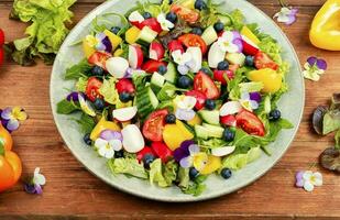 Tasty summer salad with edible flowers photo