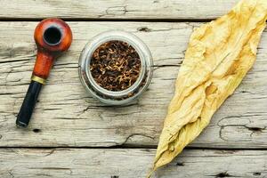 Smoking pipe with tobacco leaves photo