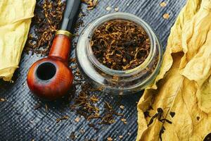 Smoking pipe with tobacco leaves photo