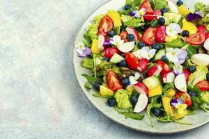 Tasty summer salad with edible flowers photo