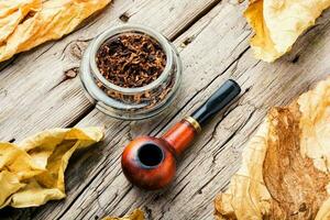 Smoking pipe with tobacco leaves photo