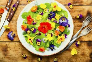 Spring salad with greens and edible flowers photo