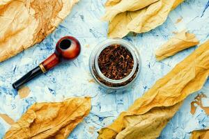 Smoking pipe with tobacco leaves,top view photo