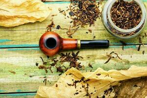 Smoking pipe with tobacco leaves,top view photo