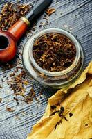 Smoking pipe with tobacco leaves photo