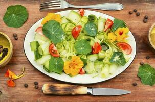 Fresh green salad with nasturtium leaves and flowers. photo