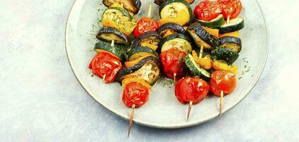 Plate with tasty vegetable skewers. photo