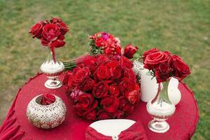 otoño brillante Boda mesa ajuste. lujoso elegante otoño Boda decoración en Marsala color. flores y platos a el Boda banquete. decorado romántico cena en rojo foto