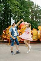 contento joven Pareja en amor teniendo divertido en un diversión parque y bailando foto