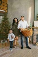 A stylish happy family is decorating their home and preparing for Christmas celebration in their country house photo