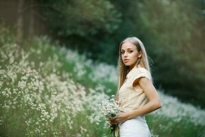 Portrait of a sweet gentle girl in a field of white flowers photo