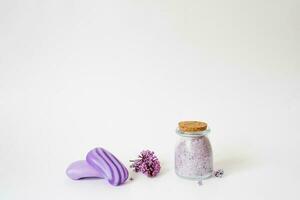 Spa care with natural soap, sea salt, washcloth glove for body care, lilac flowers and a candle on a light background with copy space photo