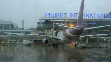 Phuket, Thaïlande 26 novembre 2017 - tablier de l'aéroport de Phuket tôt le matin pluvieux, vue depuis l'avion de remorquage video