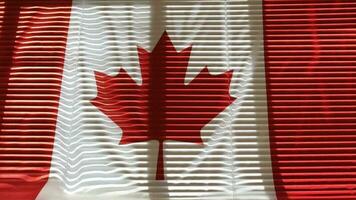 Flag of Canada is hanging at wide jalousie window.Wide angle shot video